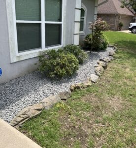 Recently landscaped bed with grey gravel mulch filling the flower beds and preventing weeds