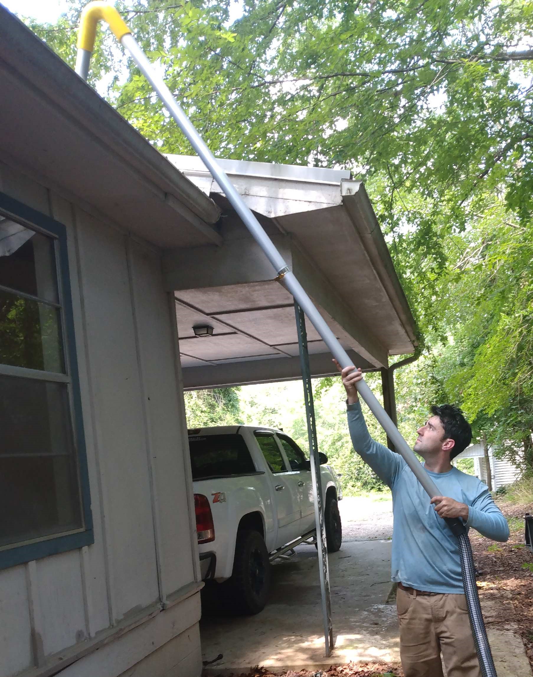 Gutter cleaning at commercial property using vacuum gutter cleaning equipment to remove gutter debris